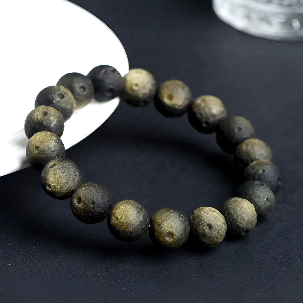 Natural obsidian crater ball bracelet with polished beads in silver or golden meteorite colours