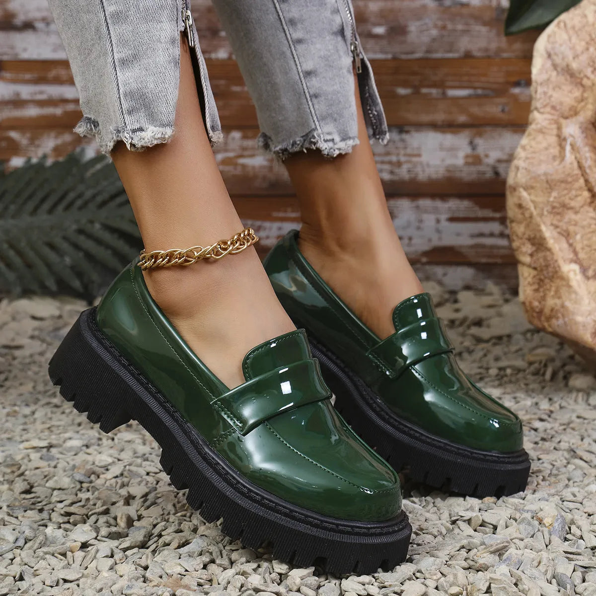Women's black slip-on loafers with a chunky platform heel and rubber sole on a neutral background.
