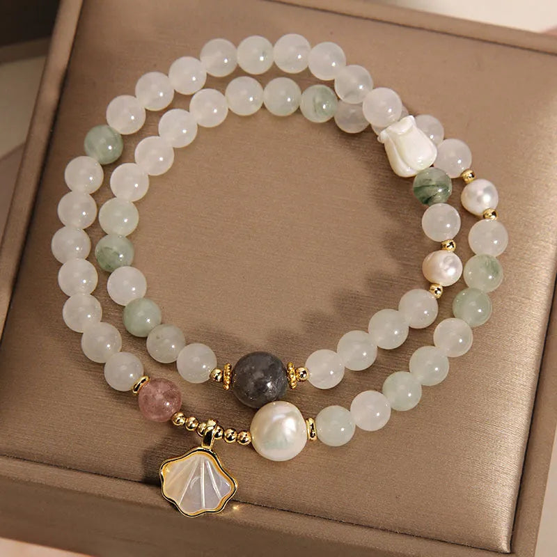 Women's artistic crystal bracelet with a green Tianshan Jade ginkgo leaf pendant and gold-plated accents.