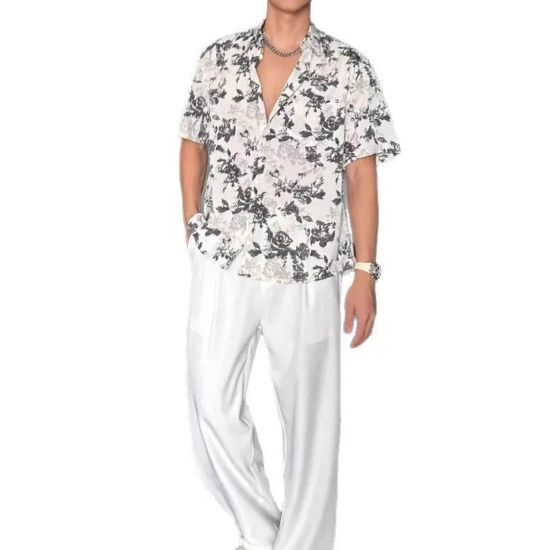 Man wearing a loose black floral print casual short sleeve shirt.