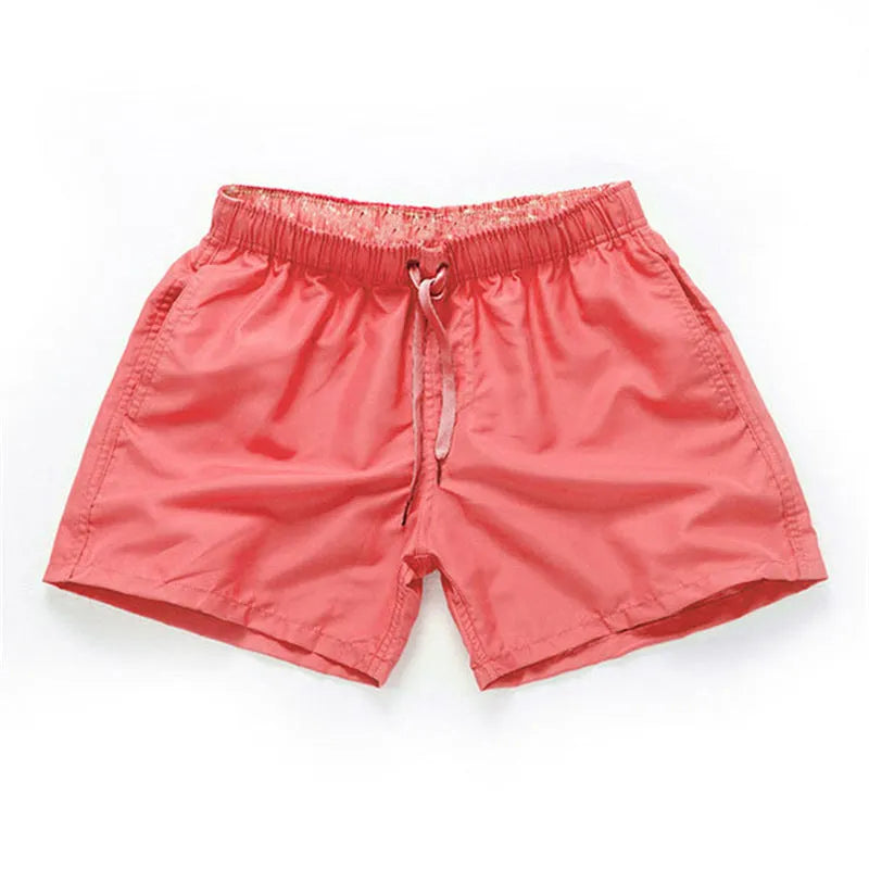 Men's black surf shorts made from polyester fabric with a straight leg opening, shown on a size chart.