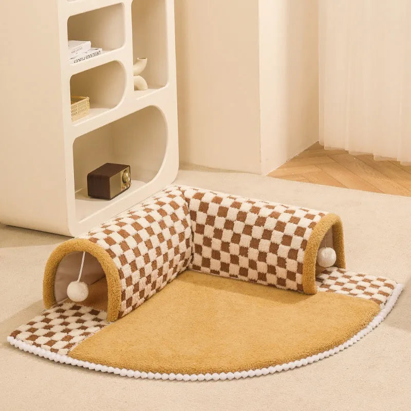 Brown plaid plush cat tunnel bed with central mat showing collapsible zipper design and non-slip bottom