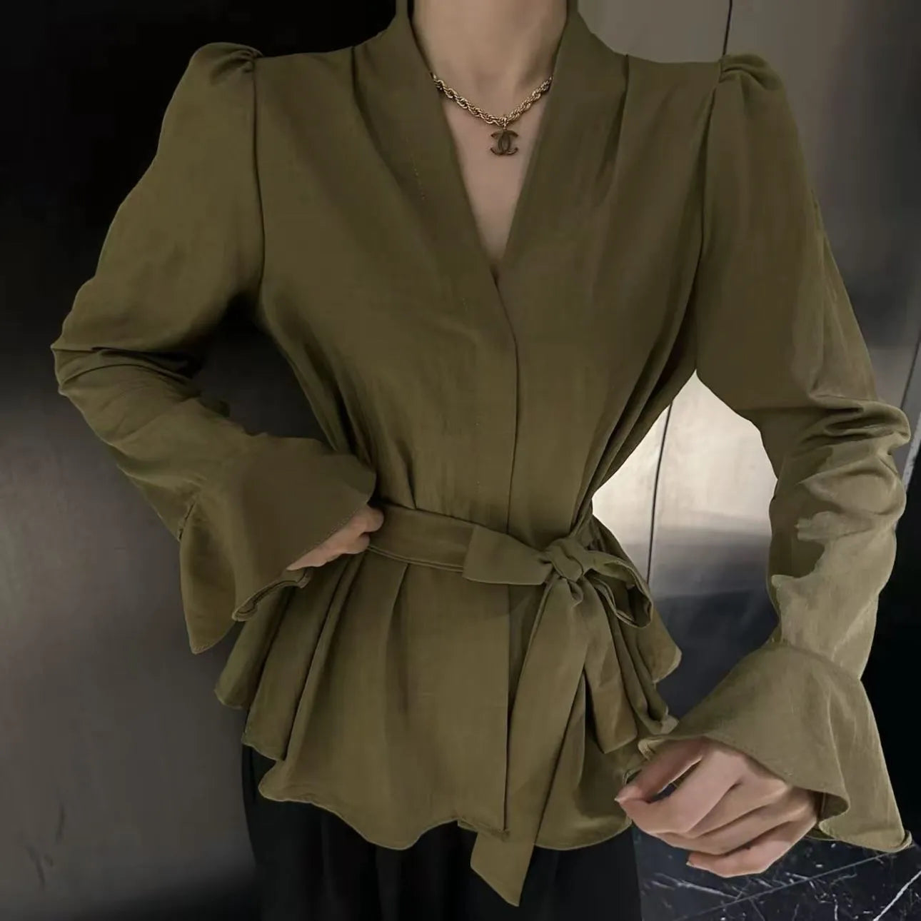 Women's black French-style shirt with irregular collar, long bell sleeves, and a tied front detail.
