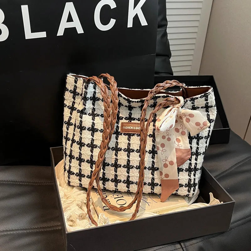 Black woven wool shoulder bag with horizontal square design showing internal organisation pockets and exterior sandwich compartment
