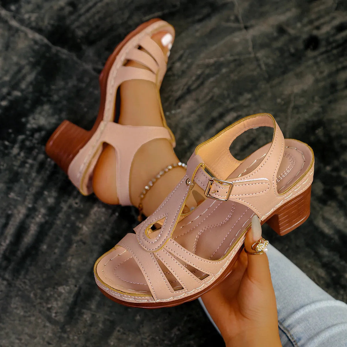 Women's black peep toe wedge platform sandals with a buckle fastening on a wooden surface.