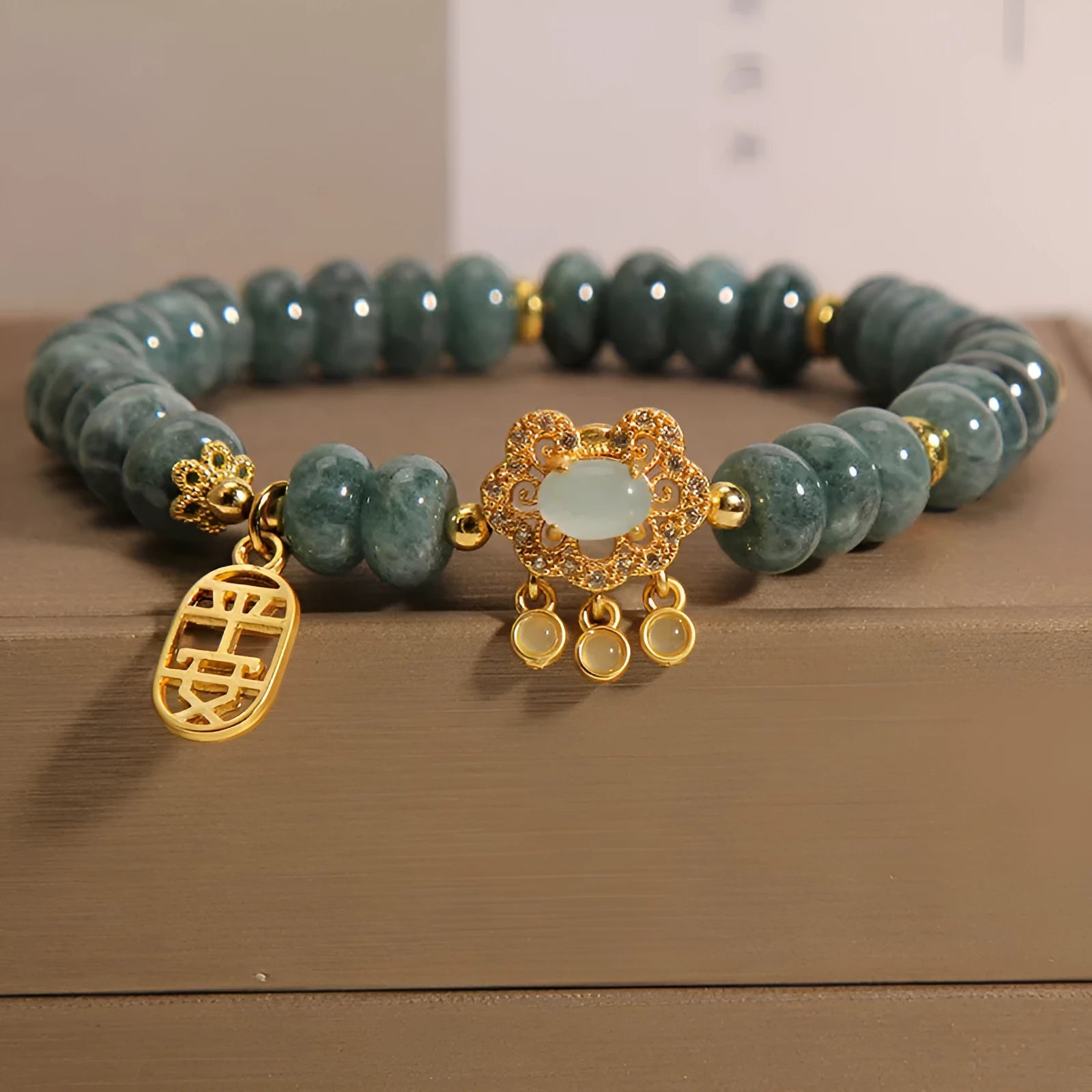 Close-up of a women's bracelet with emerald green jade abacus beads and a metallic safety lock clasp.