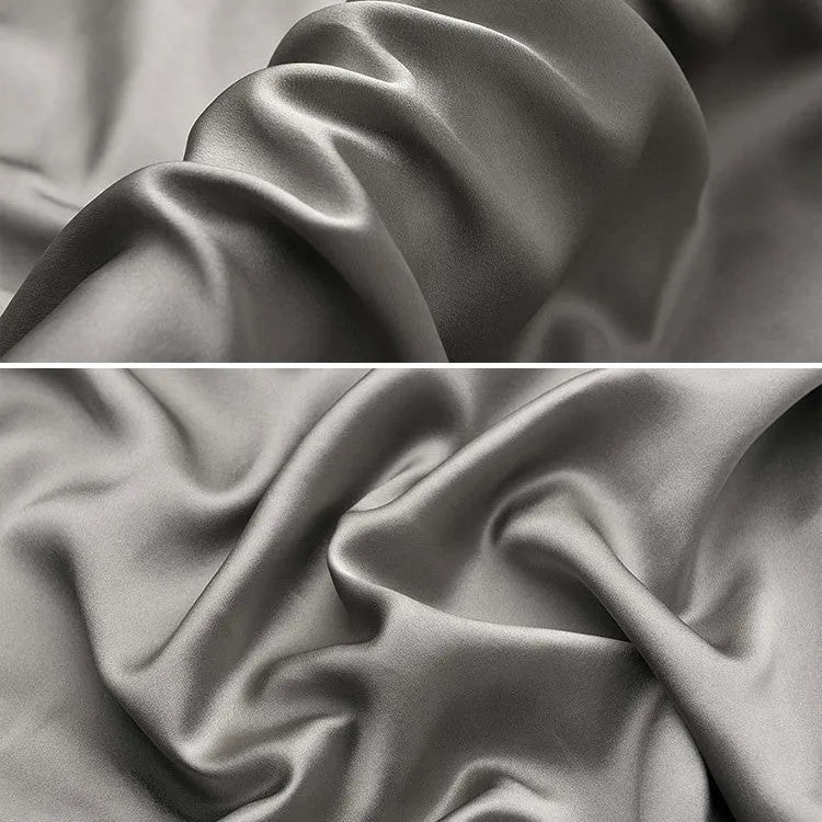 Solid colour mulberry silk envelope pillowcase in dark grey on a bed.