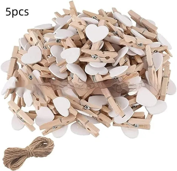 Set of five solid wood heart-shaped clips in different colours on wooden surface