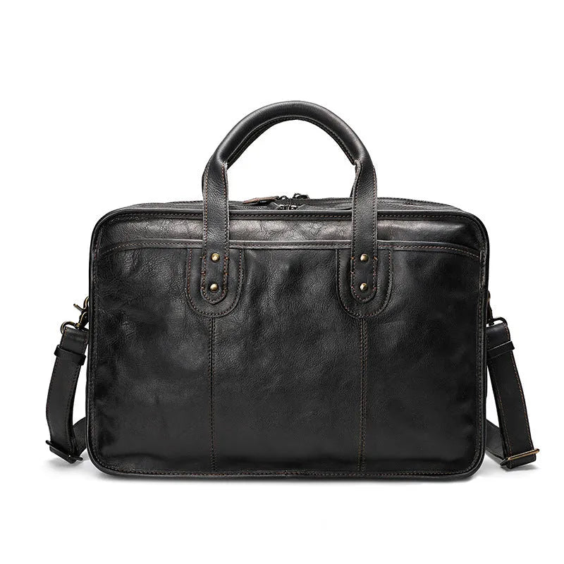 Black vintage leather men's briefcase open to show internal laptop pocket, camera pocket, and document organisation.