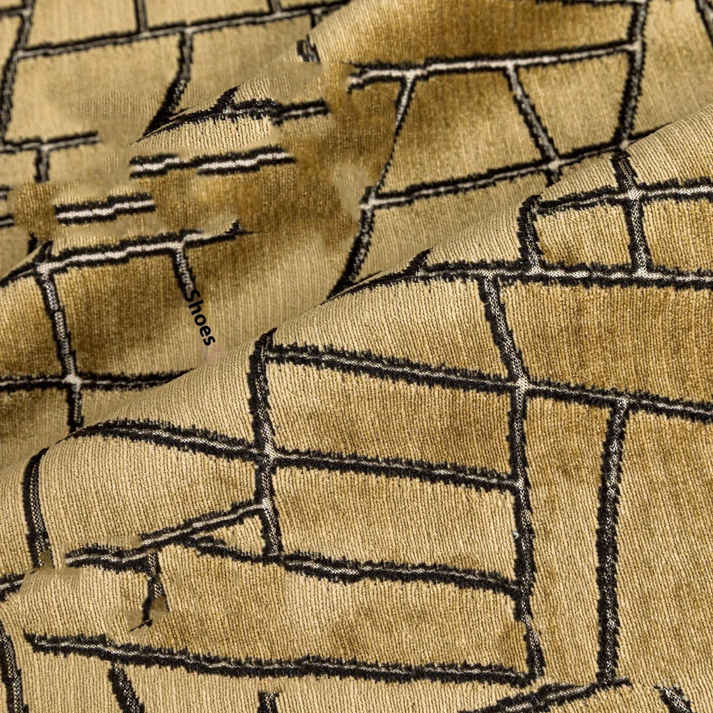 Gold geometric abstract pattern on a square polyester cushion cover with tassel detail.