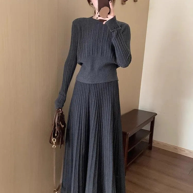 Women's dark grey knitted sweater and skirt suit set with textured 3D pattern and collage stitching.