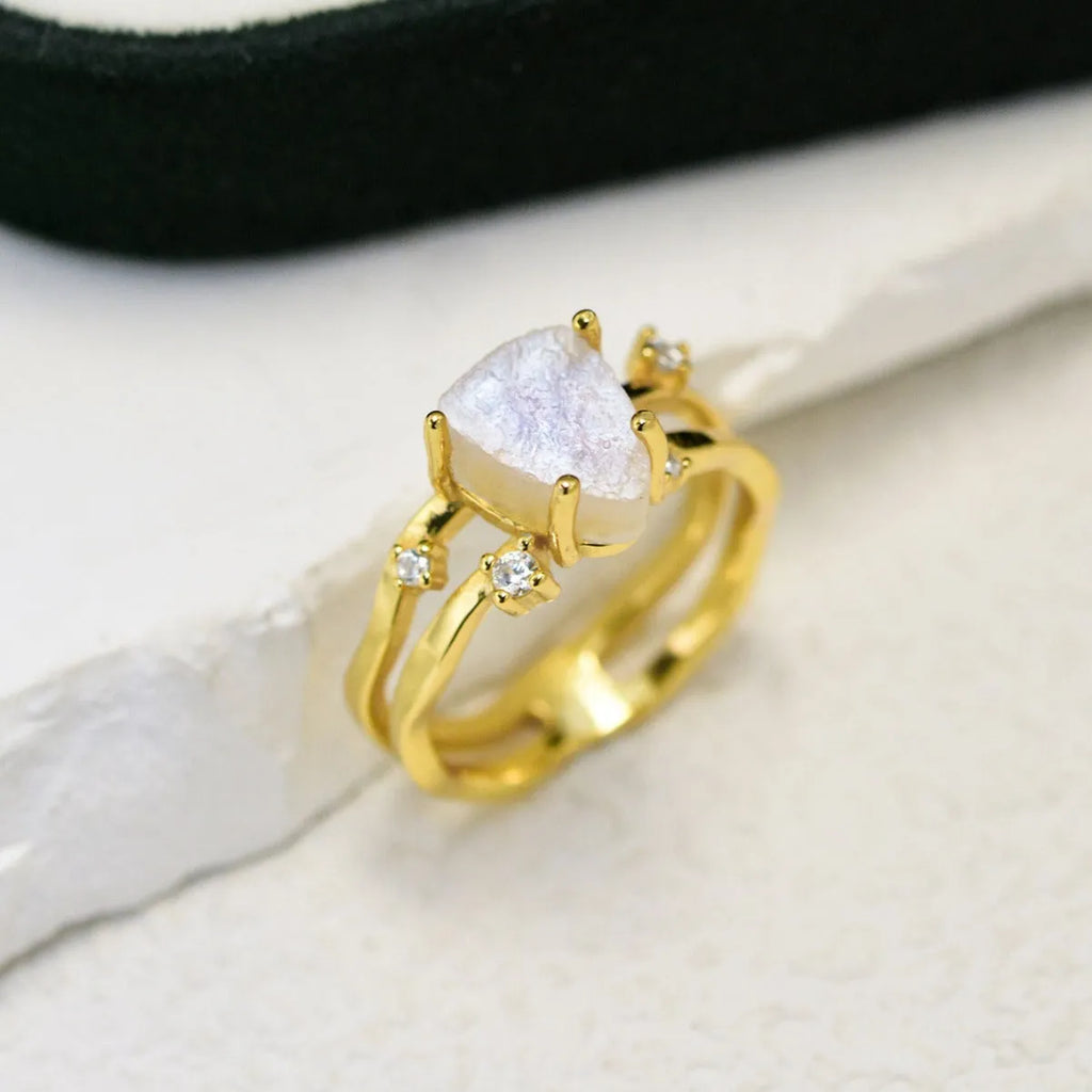 S925 silver geometric ring with irregular triangle shape and central moonstone on a model's hand.