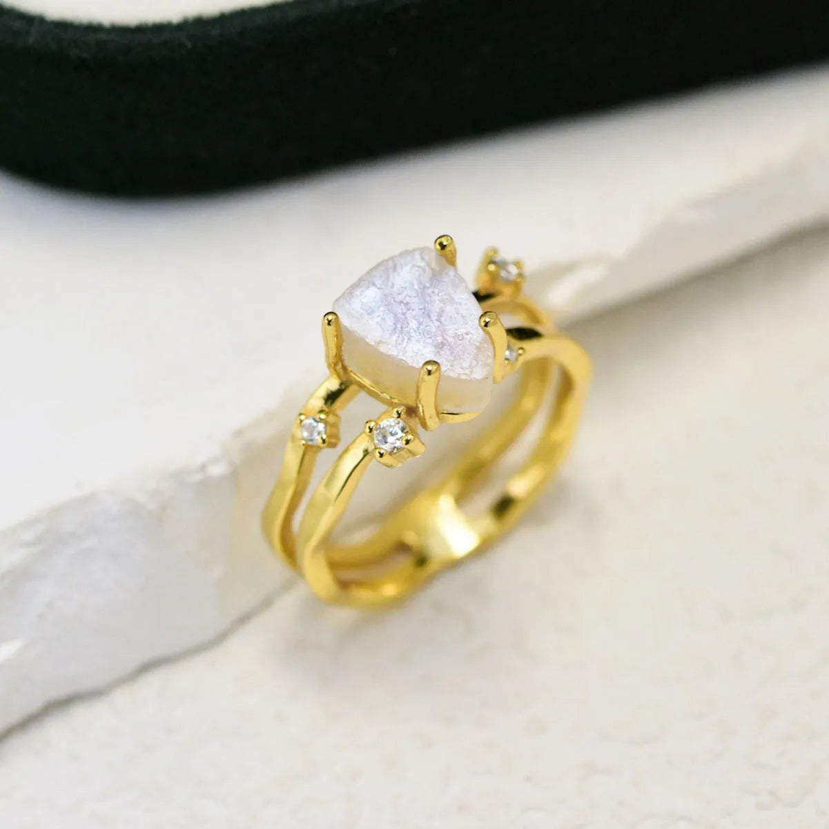 S925 silver geometric ring with irregular triangle shape and central moonstone on a model's hand.