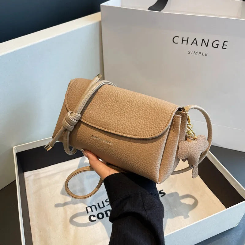 Soft PU small shoulder bag in khaki with pillow silhouette and sewing thread detail, 21cm wide.