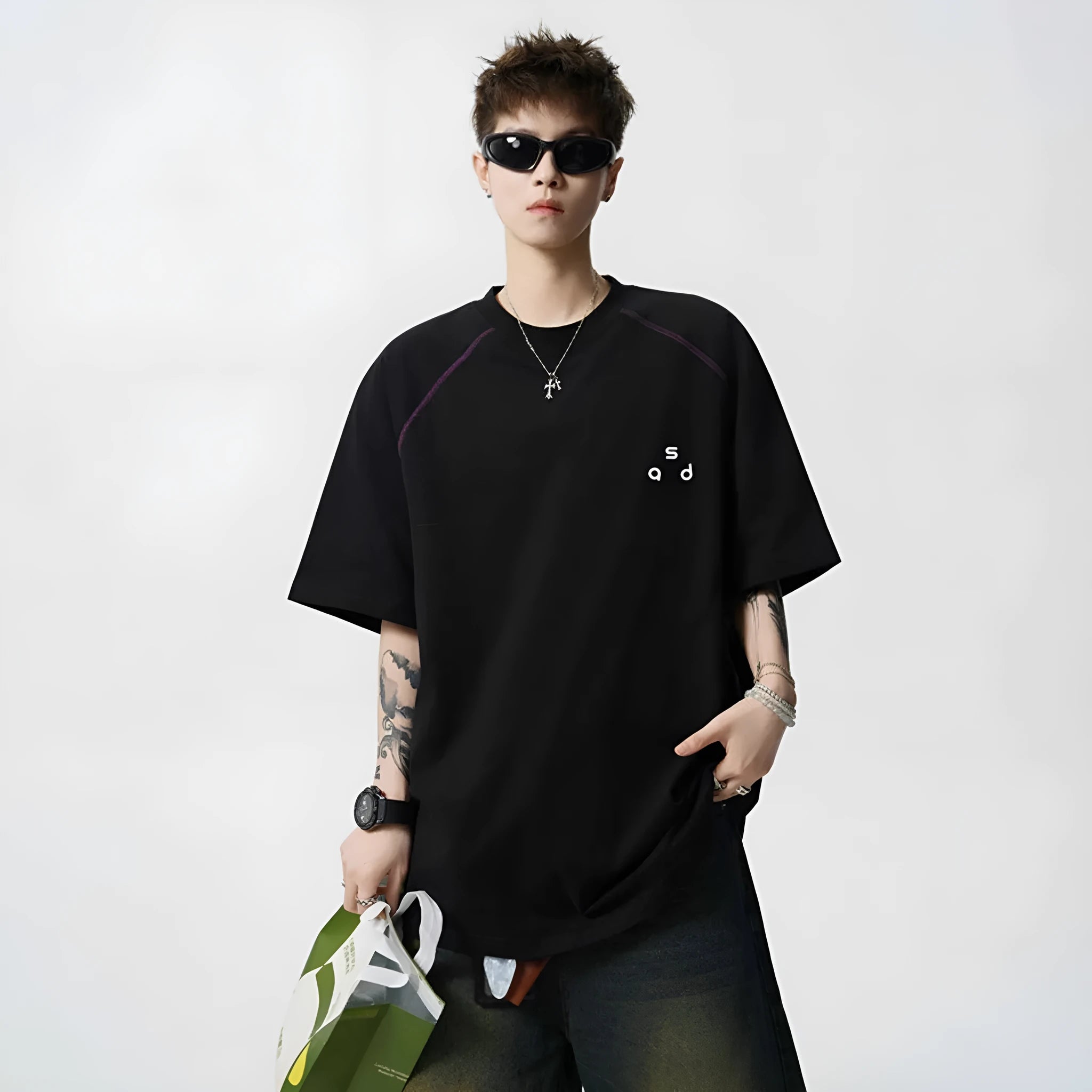 A loose-fitting black cotton t-shirt with letter print detail on the front, showing short sleeves and a round neck.