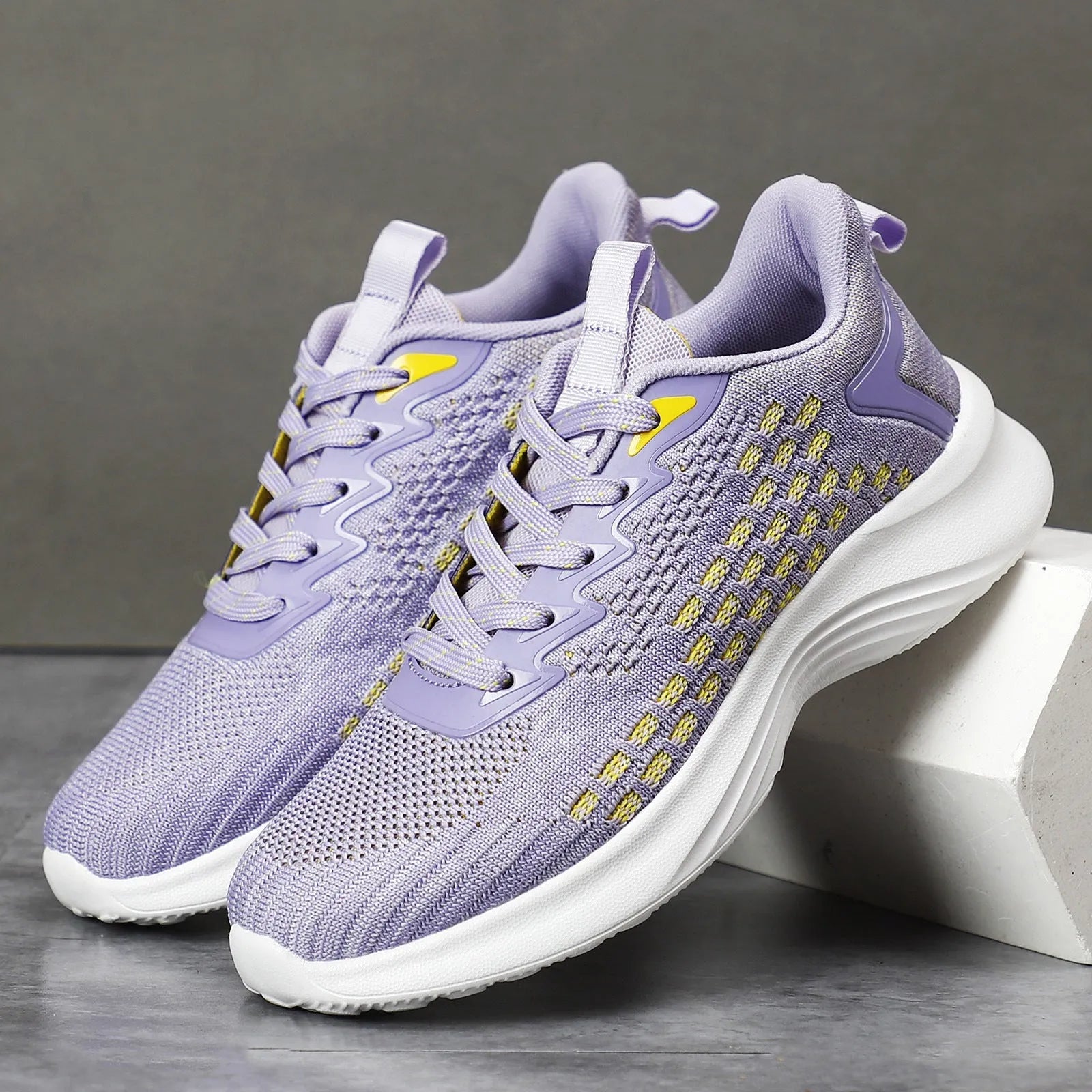 Lavender purple women's Flyknit running shoes with striped pattern, mesh lining, and a flat EVA wedge sole.