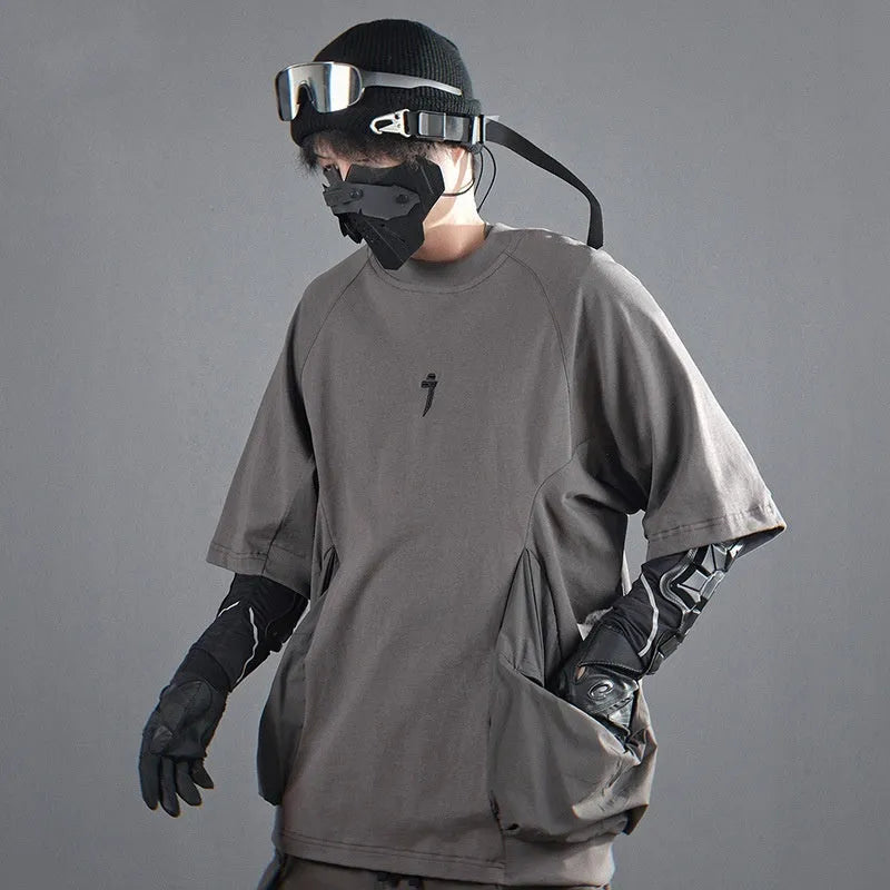 Men's loose grey cotton t-shirt with large chest pockets and short sleeves on a mannequin.