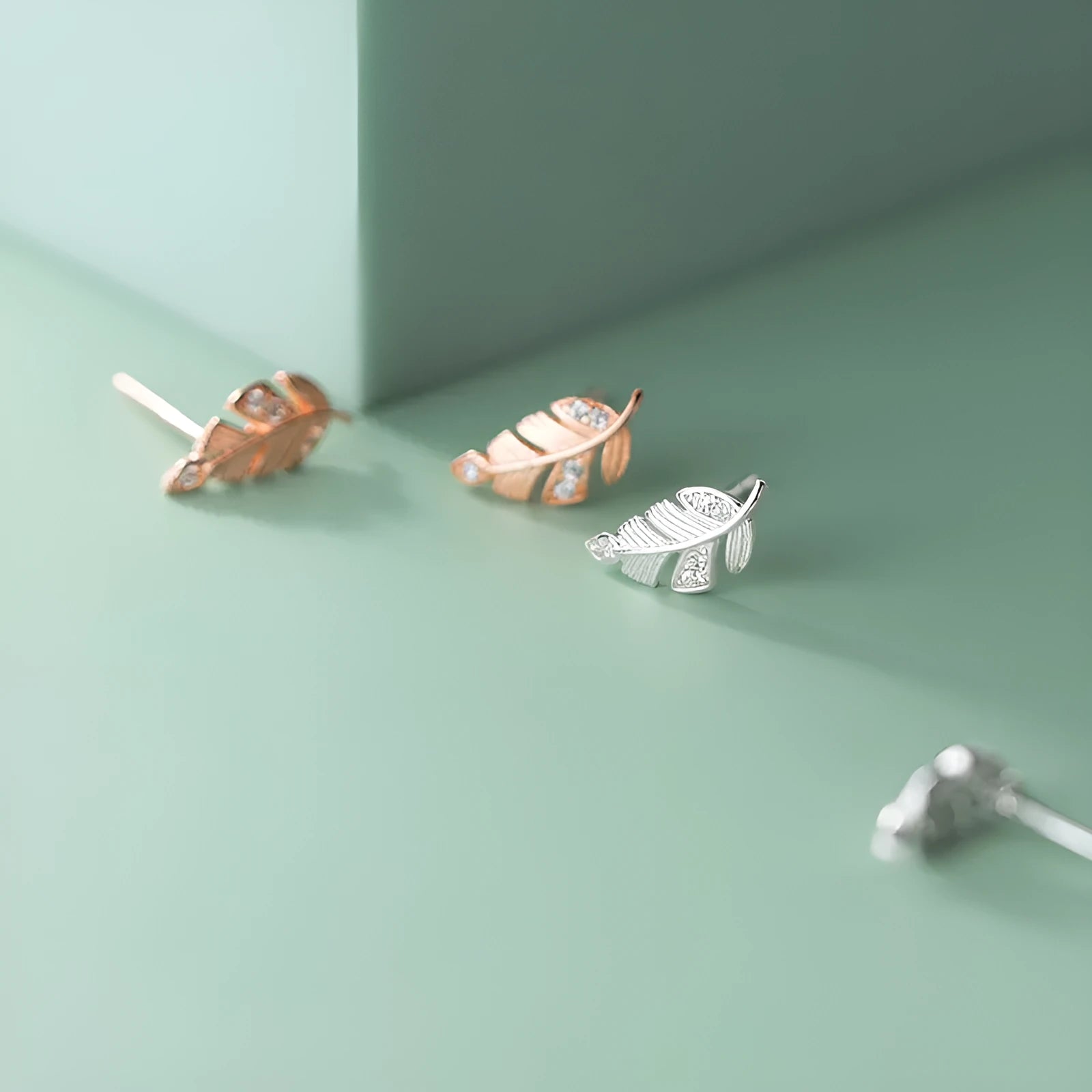 Copper willow leaf stud earrings with micro-inlaid leaf detailing, rose gold or white gold finish, side view on white background