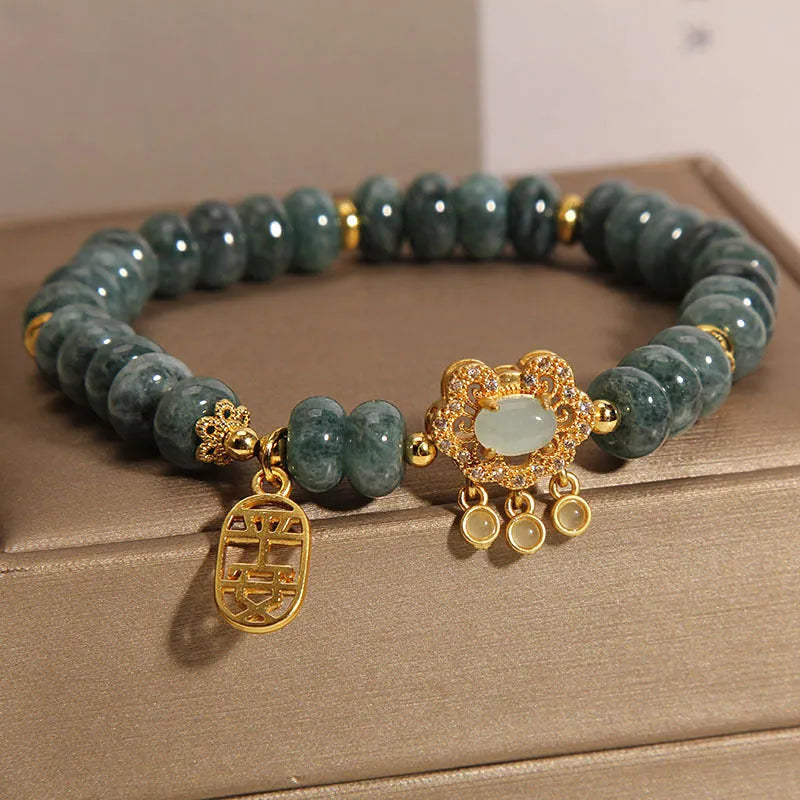 Close-up of a women's bracelet with emerald green jade abacus beads and a metallic safety lock clasp.