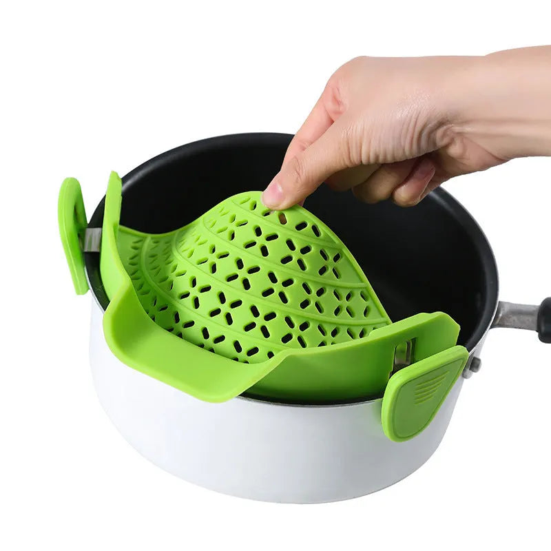 Silicone pot side drain stopper in black attached to saucepan rim with leak-proof edge
