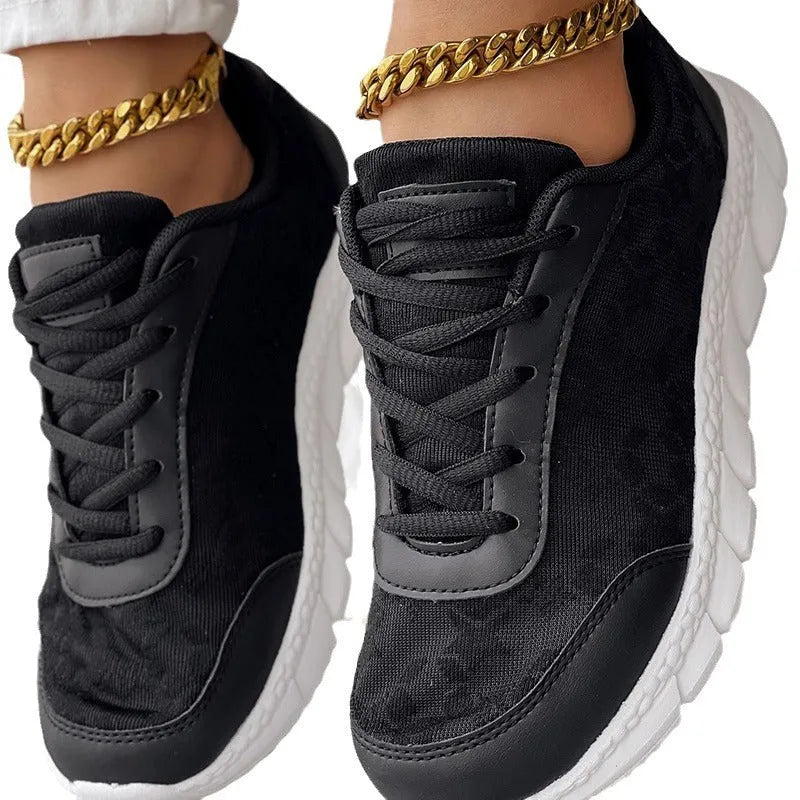Women's white canvas running shoes with round toe and flat heel on a light background