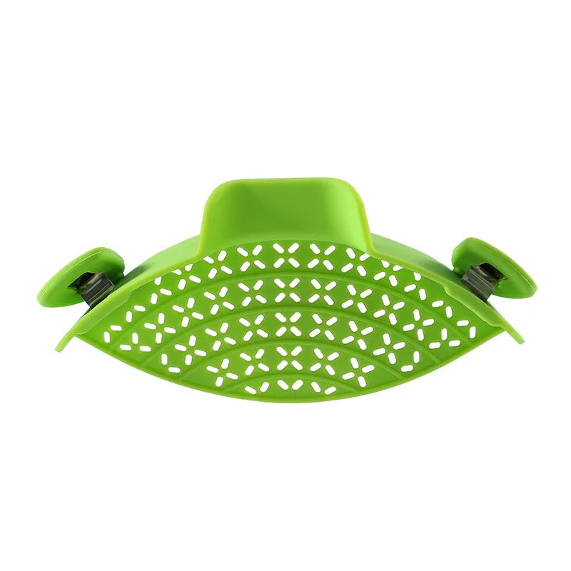 Silicone pot side drain stopper in black attached to saucepan rim with leak-proof edge