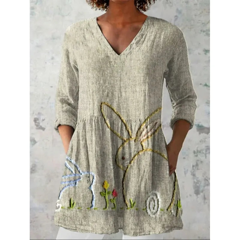 A woman wearing a loose-fitting printed dress with 3/4 sleeves and a wide waist.