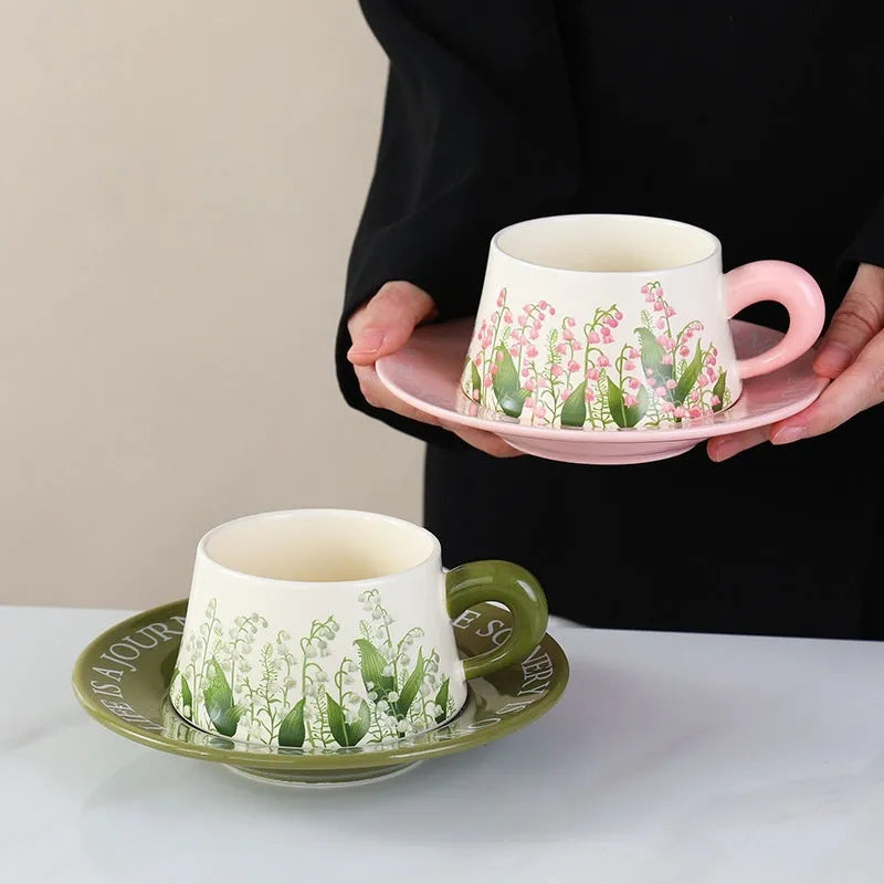 Ceramic coffee cup and saucer set for couples with stirring spoons in two design options.