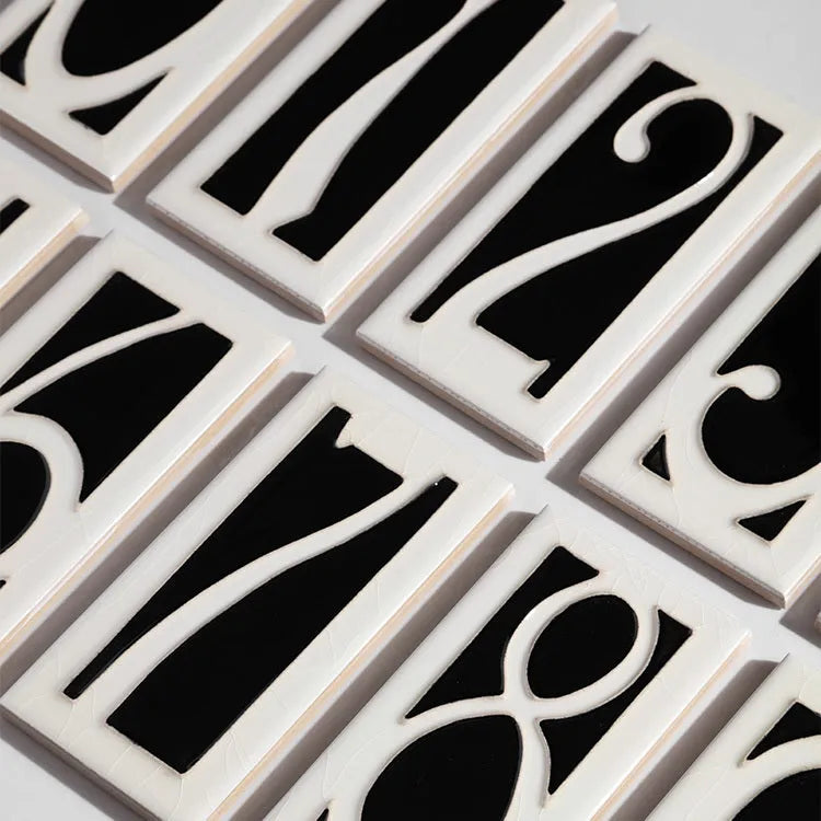 Handmade retro enamel ceramic doorplate showing a number on a glossy surface
