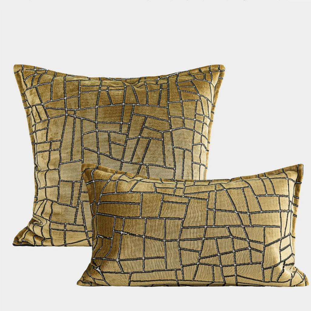 Gold geometric abstract pattern on a square polyester cushion cover with tassel detail.