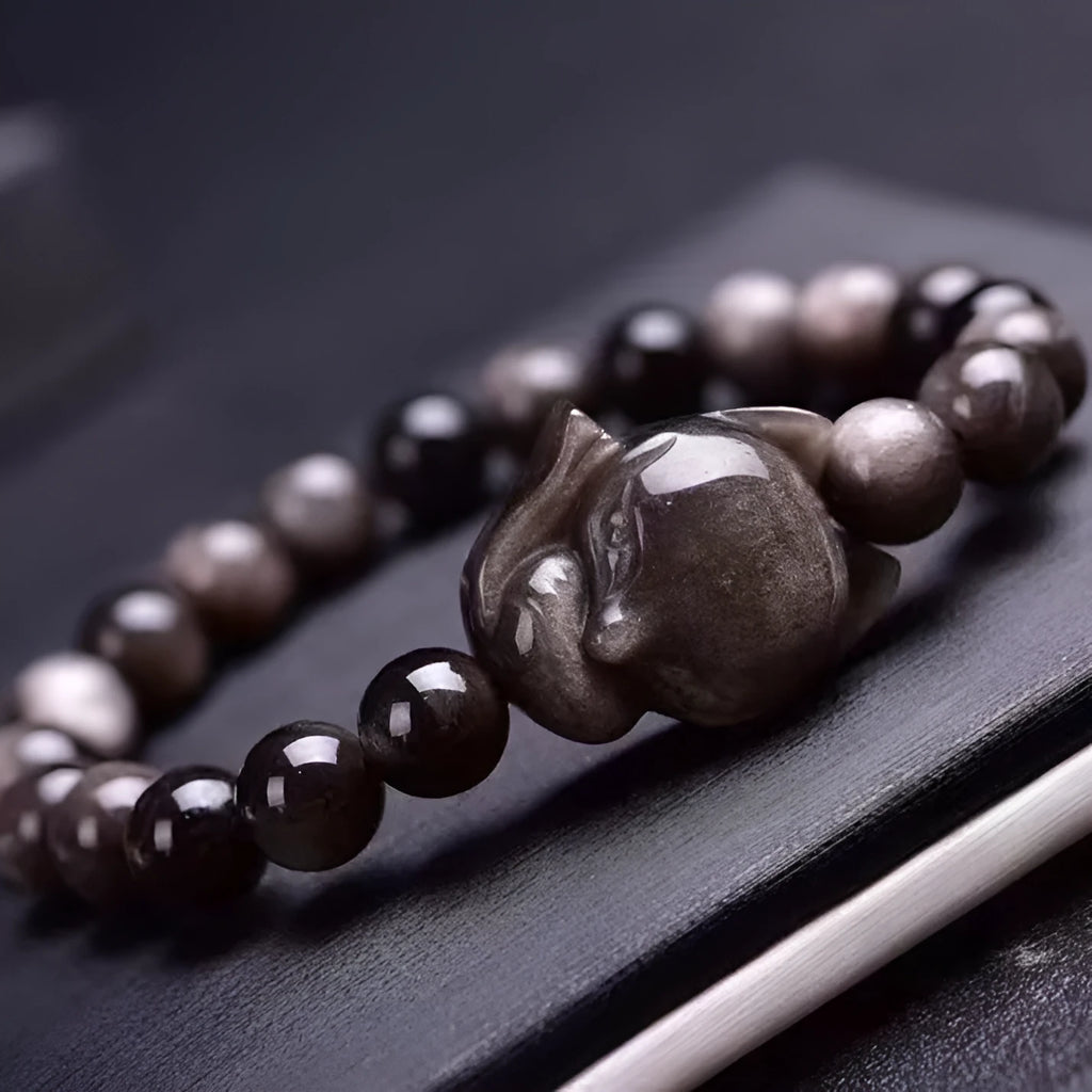 Close-up of a women's adjustable bracelet with a dark obsidian fox bead and sliding knot.