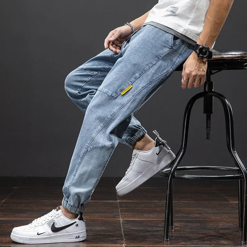 Man wearing loose blue cargo jeans with straight leg and mid waist.