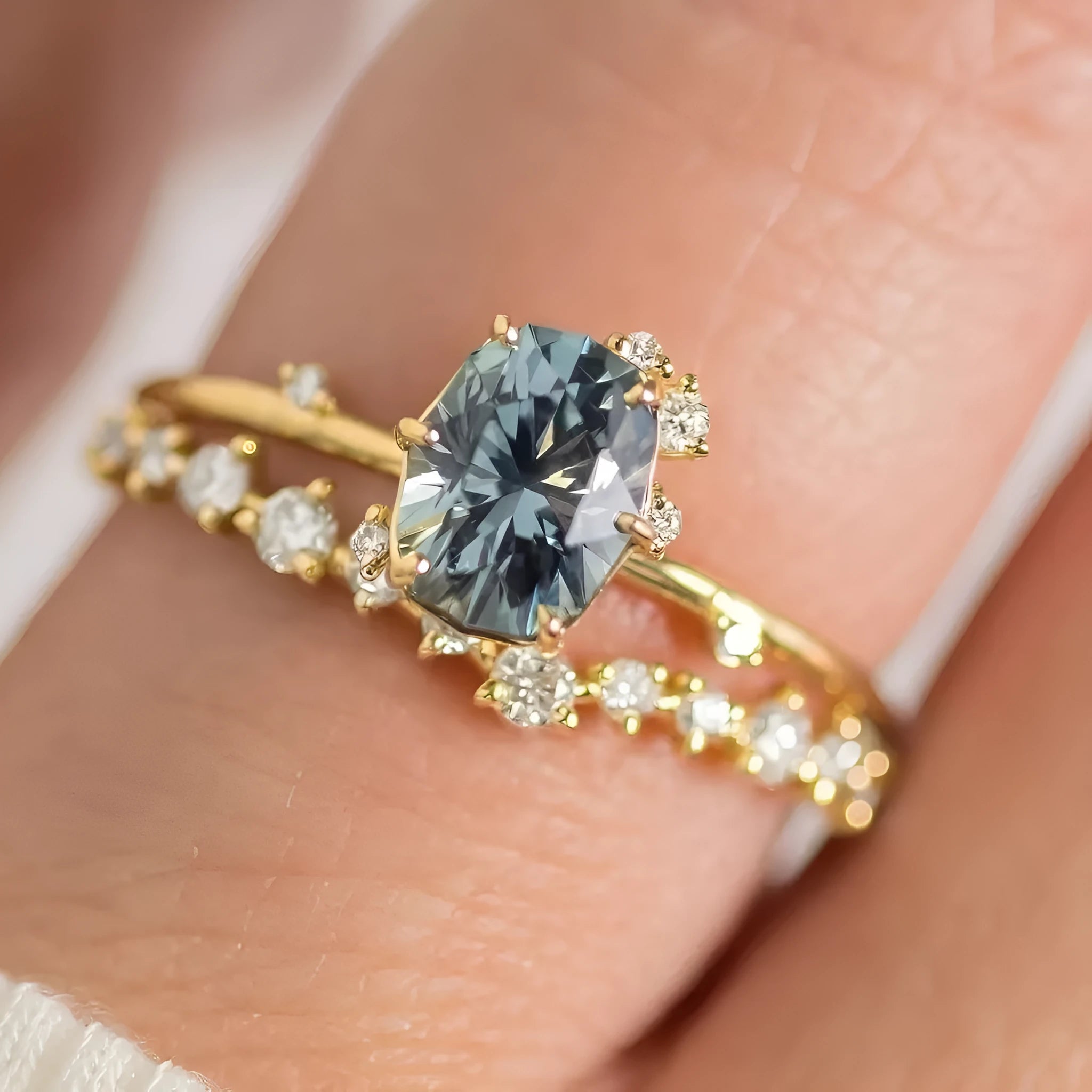 Gold plated women's ring with green zircon stone in floral design on a model's finger.