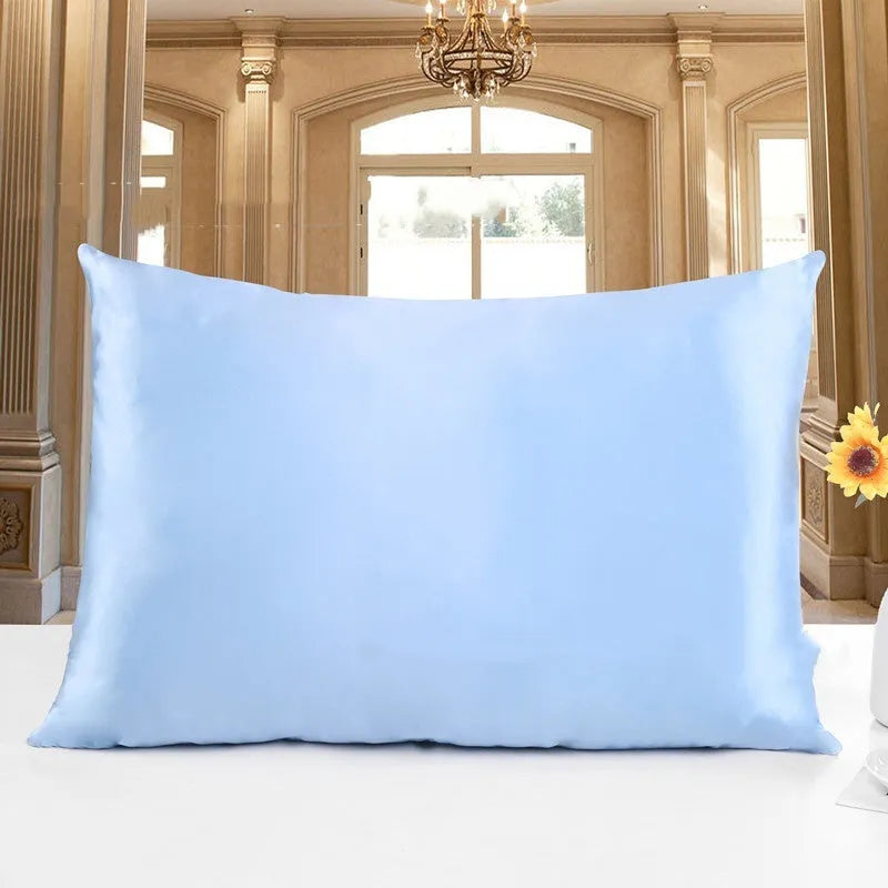 19 M double-sided silk pillowcase in apricot colour on a bed.