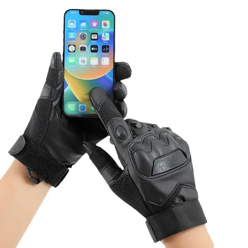 Men's black full finger tactical gloves with touch screen fingertips on a hand holding a phone.