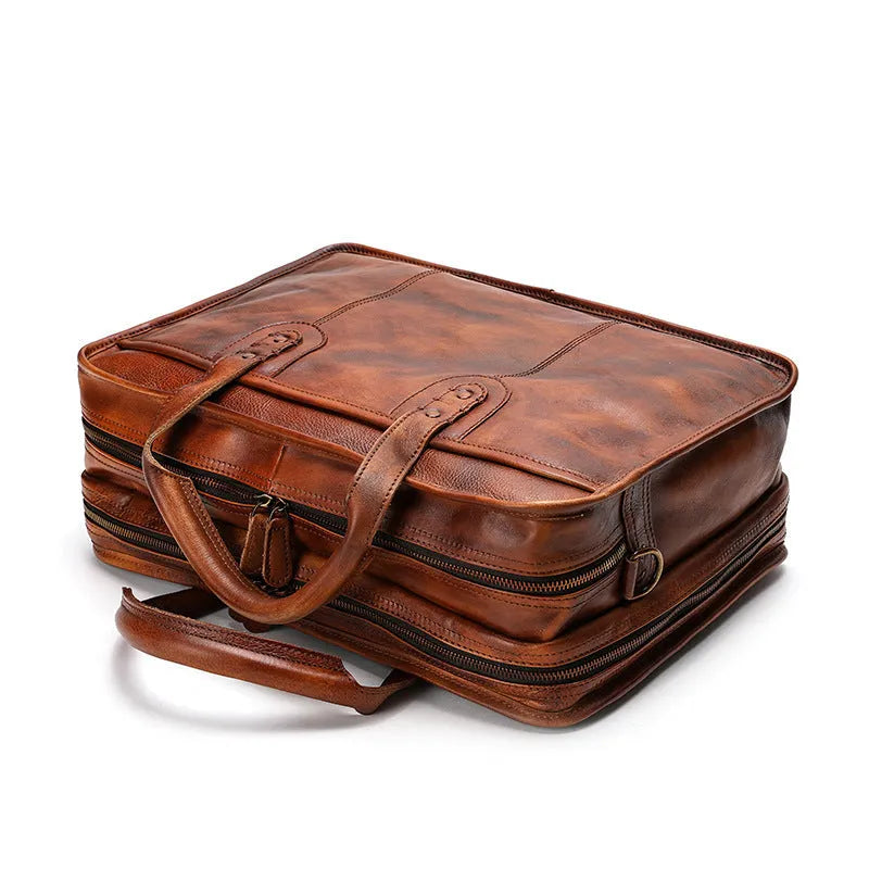 Black vintage leather men's briefcase open to show internal laptop pocket, camera pocket, and document organisation.