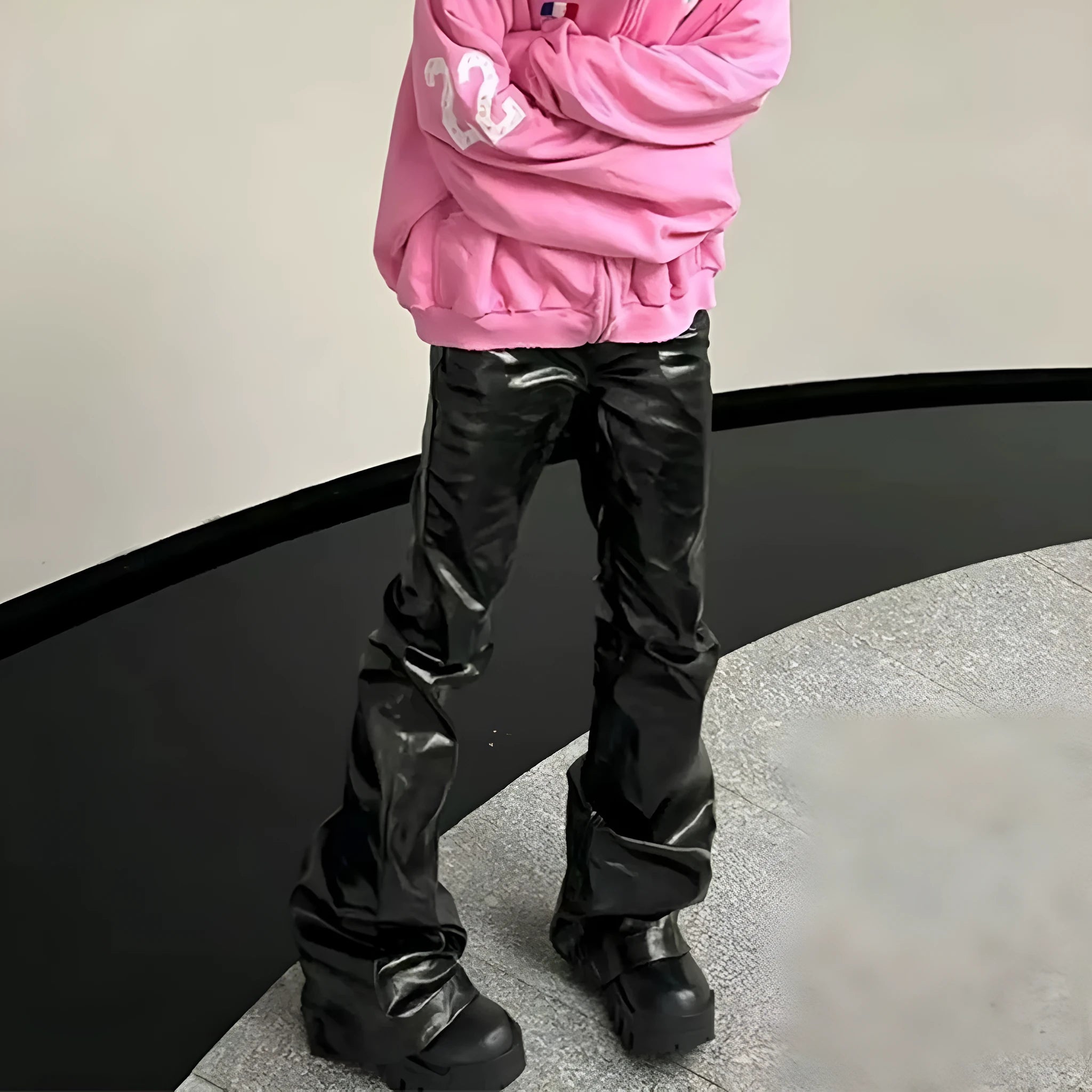 Black women's skinny jeans with a shiny patent leather finish and straight-leg cut.