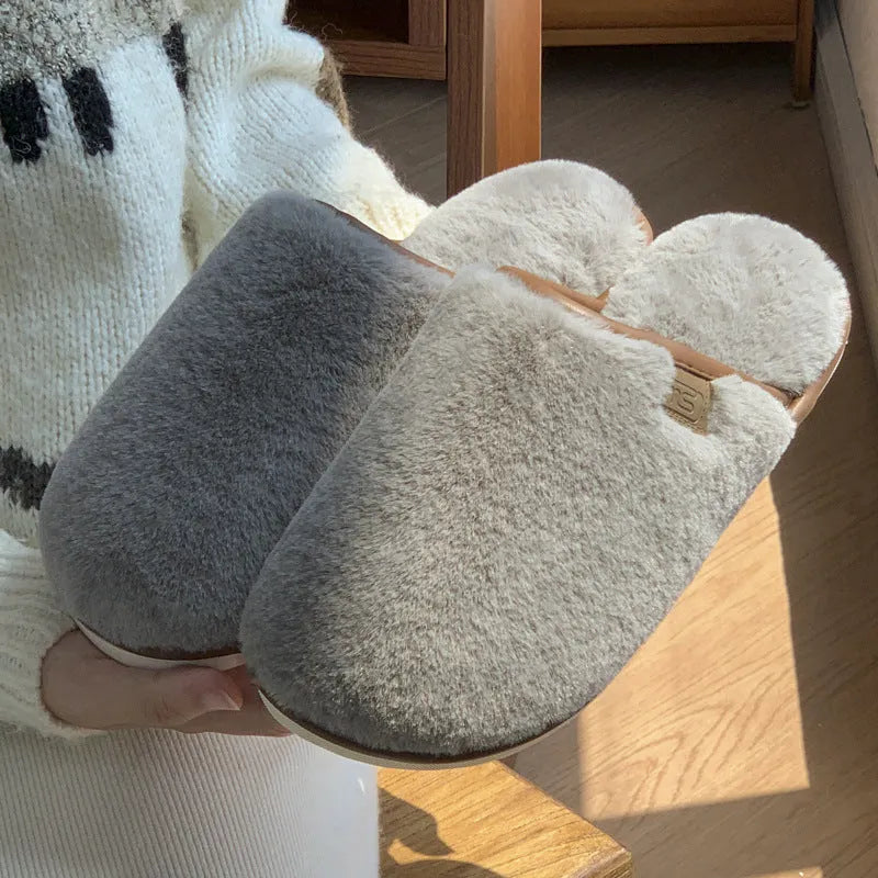 Solid colour PVC plush winter house slippers on a wooden floor.