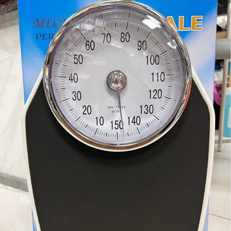 Black mechanical bathroom scale with large analogue dial display on white background