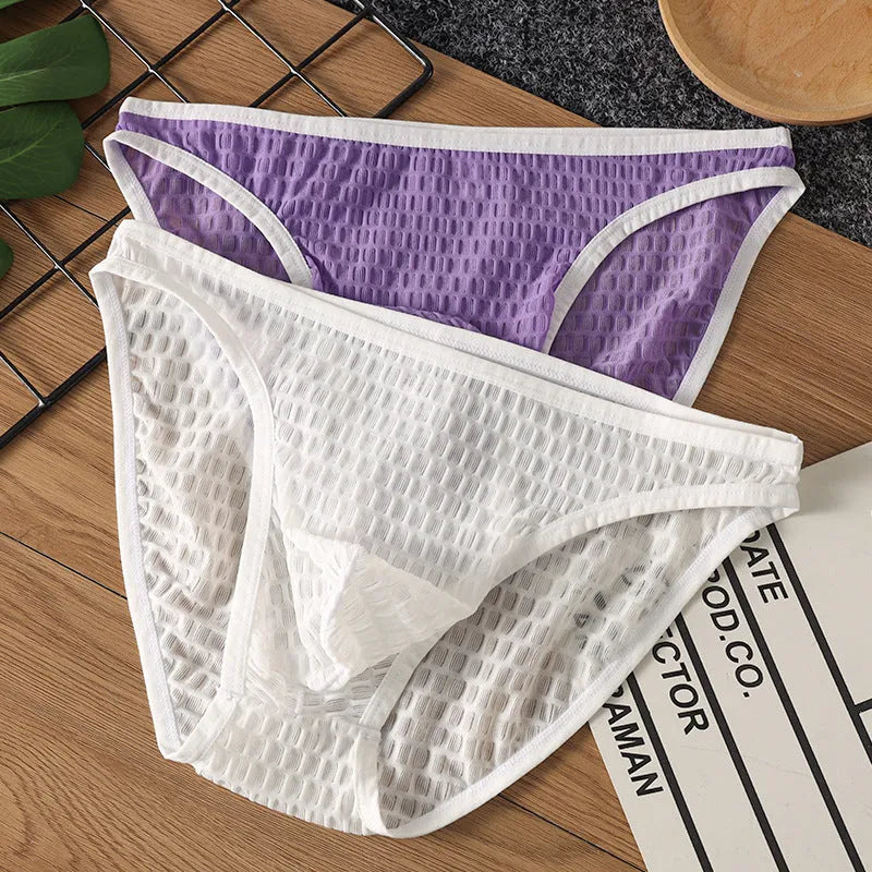 Men's low waist transparent lace underwear shorts in a solid colour on a neutral background.
