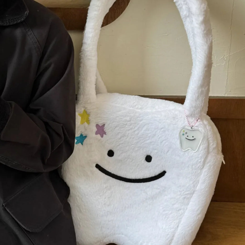 White plush shoulder tote bag with large tooth pattern decoration and zipper closure