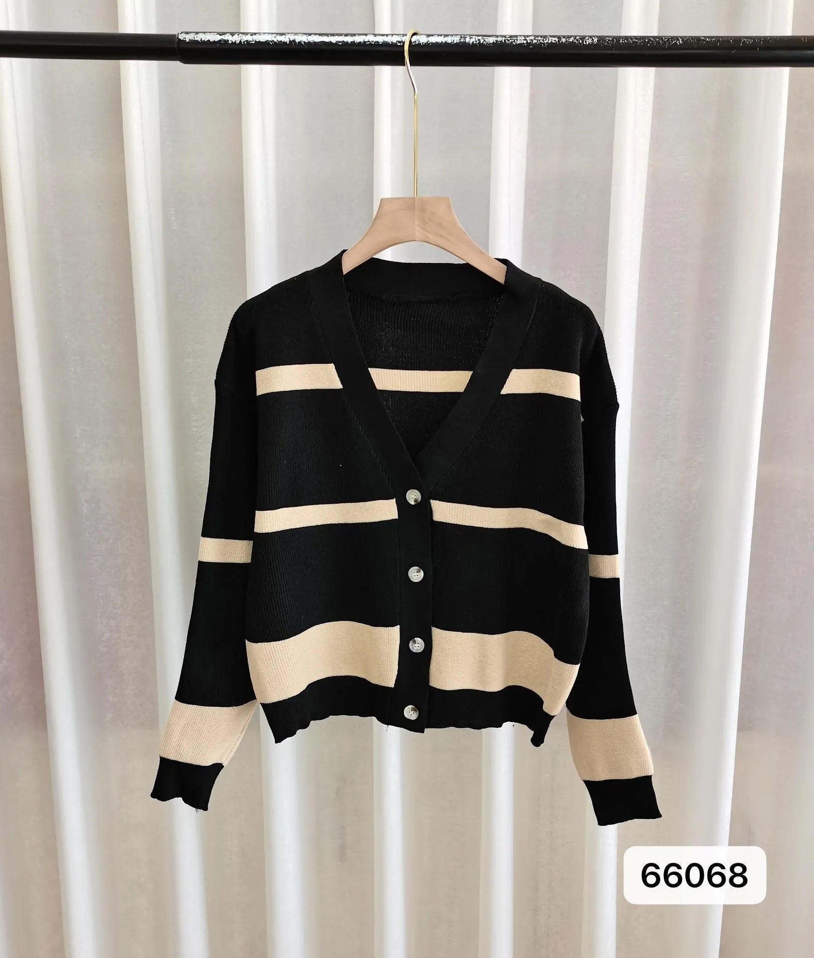 Women's black and white striped V-neck knitted cardigan with 3D pattern on a hanger.