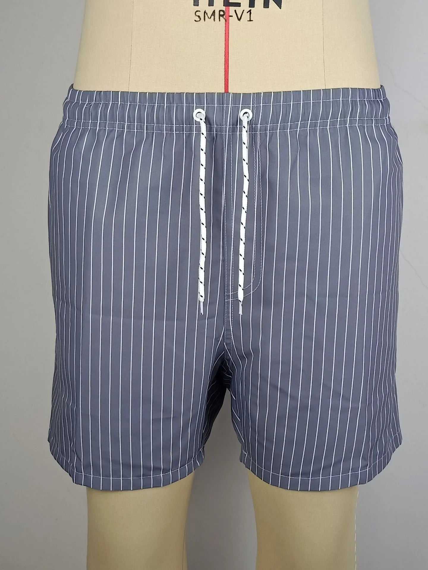 Men's striped beach shorts in navy blue, made from polyester fibre with a straight leg opening.