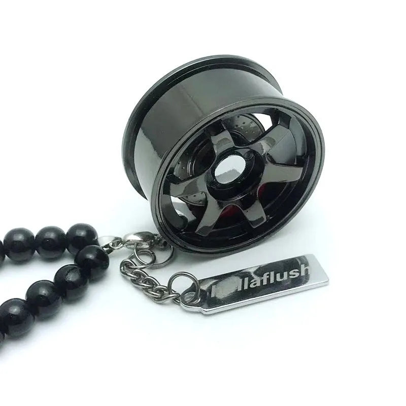 Stainless steel car tyre ornament with crystal glass bead chain hanging from a rearview mirror