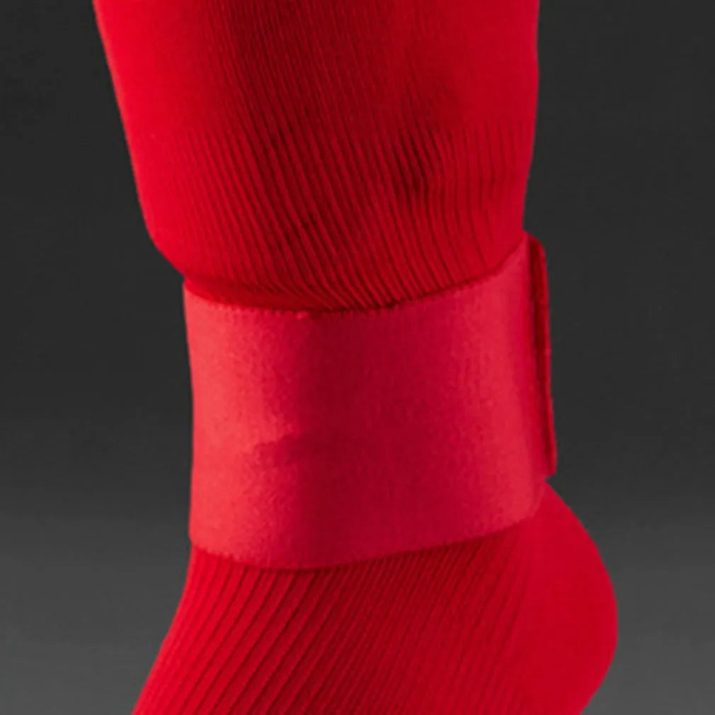 Red rubber football shin guard securing tape belt shown alongside football equipment