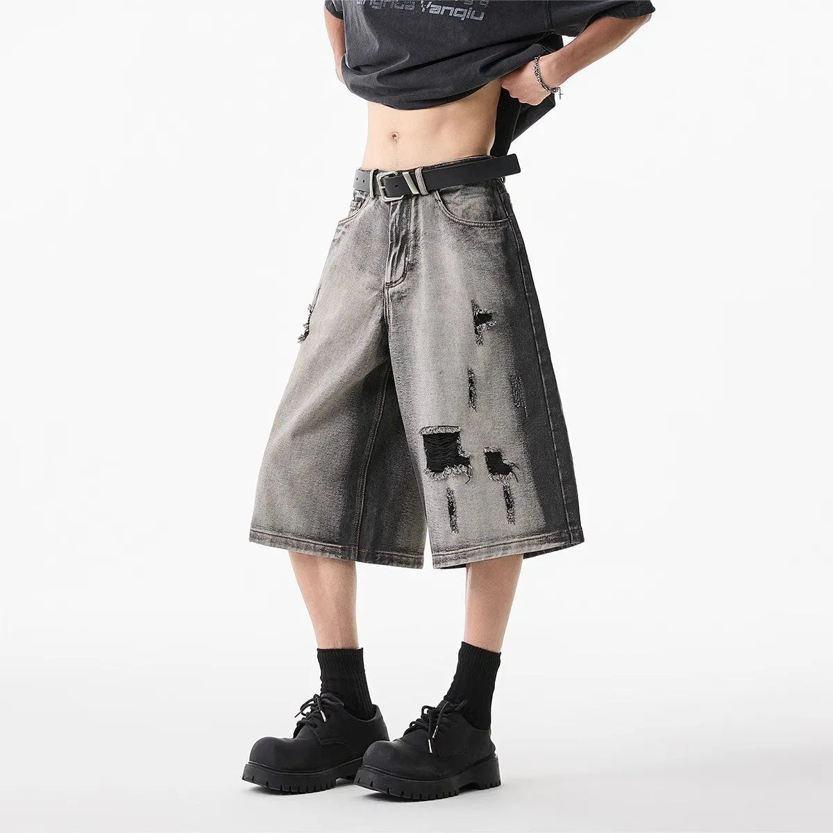 Grey cotton denim shorts with distressed hole finish and loose cropped fit