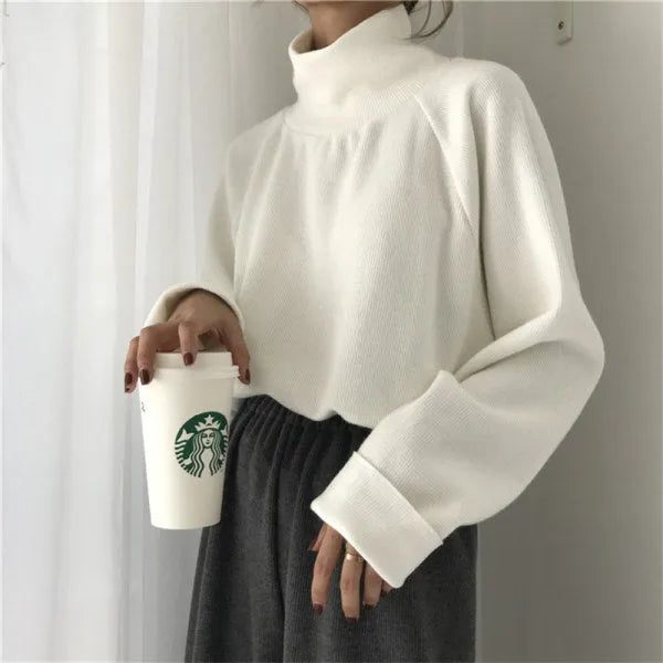 Women's loose-fitting long sleeve top with a half-high collar in a solid colour.