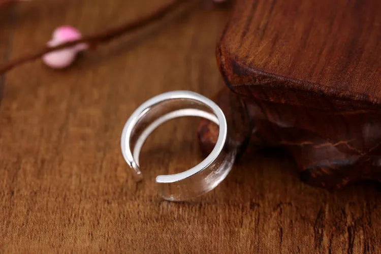 Frosted silver geometric open ring with adjustable sizing on a neutral background