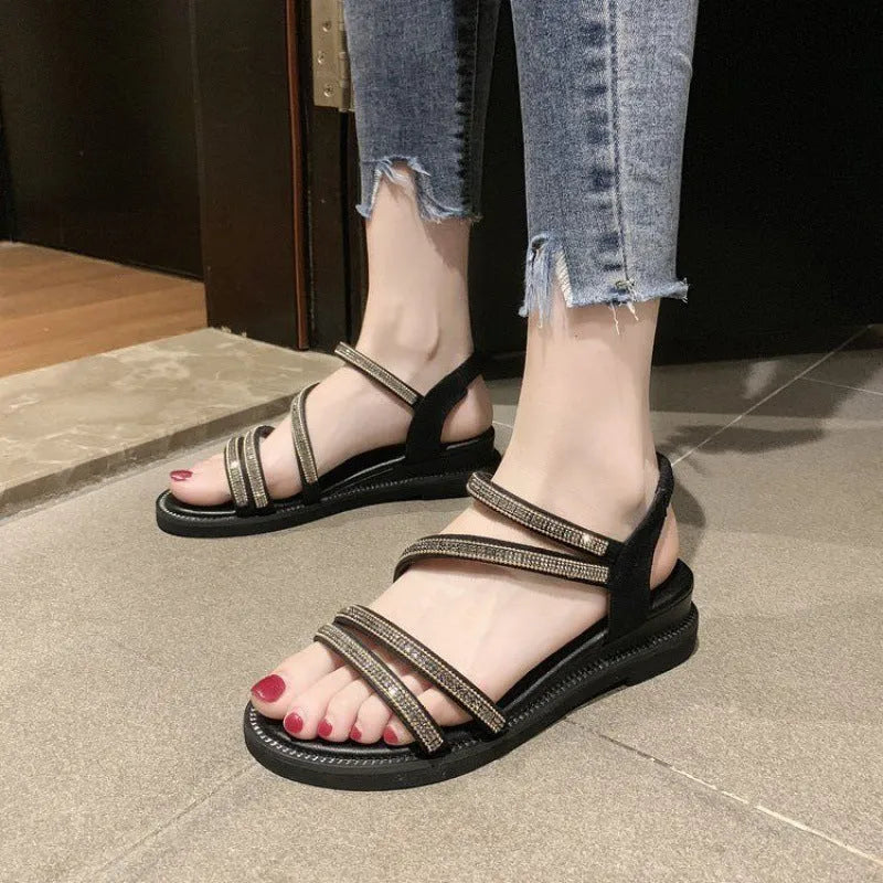 Women's silver flat sandals with rhinestone detail, round toe, and elastic band strap.