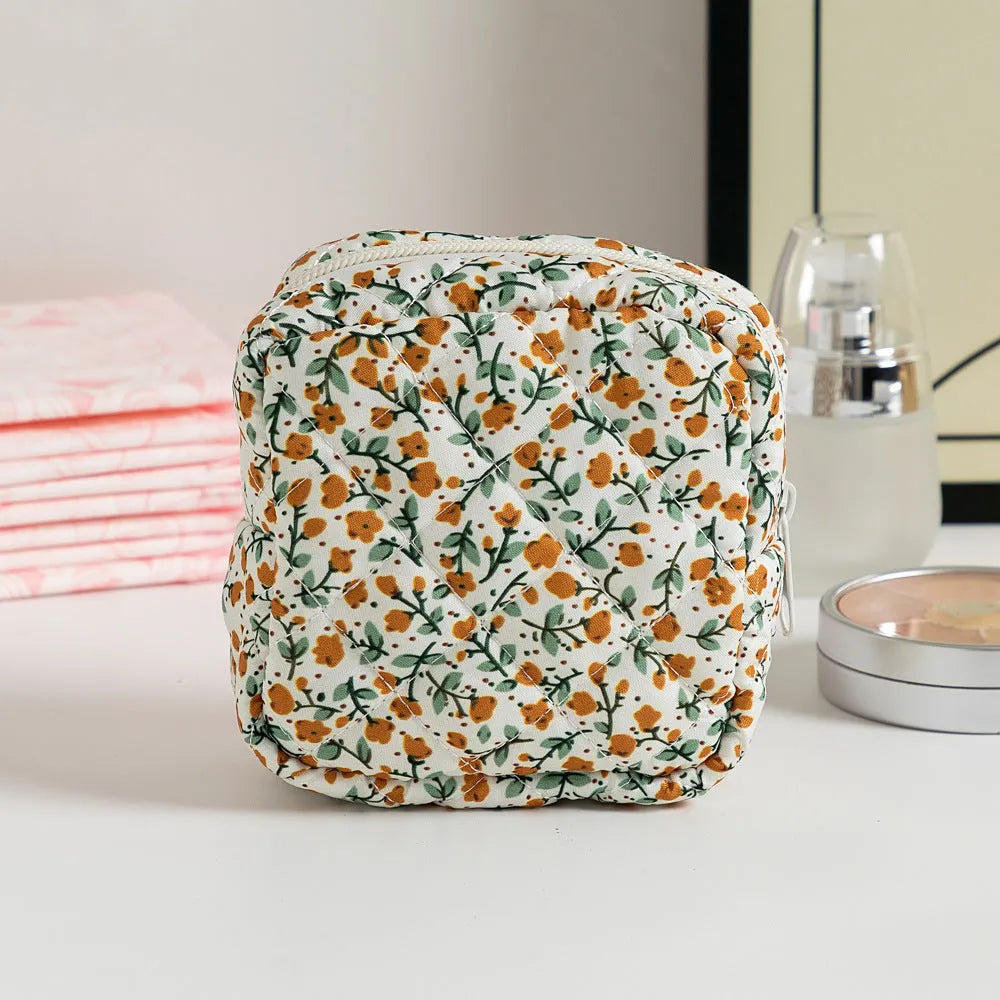 Yellow floral polyester key storage bag with sewing thread detail next to red small flower design variant.